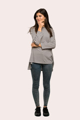 A full-length shot of a Teenager girl with striped shirt looking to the side over isolated background