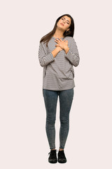 A full-length shot of a Teenager girl with striped shirt having a pain in the heart over isolated background