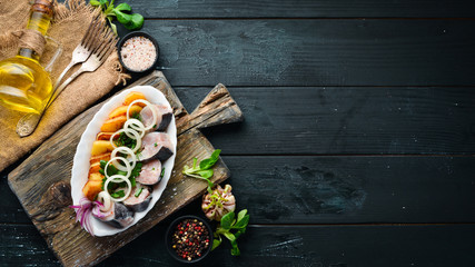 Salted fish with potatoes and onions. Ukrainian Traditional Cuisine. On the old background. free copying space.