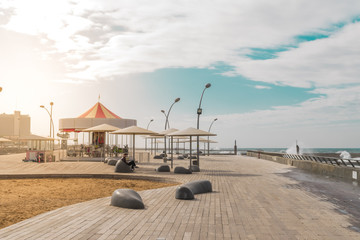 View of Namal promenade at Tel Aviv Port, Israel. Sunset at harbour deck with carousel and...