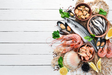 Seafood on a white wooden background. Fresh fish, shrimp, oysters and caviar. Top view. Free copy...
