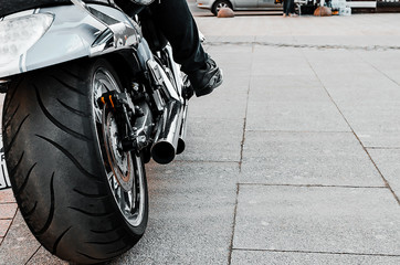 Motorcycle wheel close up on the road. Biker sitting on a motorcycle close-up.
