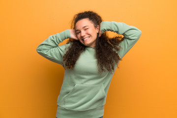 Happy Teenager girl over ocher wall.
