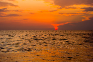 Amazing sea sunset on the pebble beach, the sun, waves, clouds