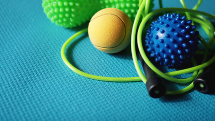 Massage ball and roller for self massage, reflexology and myofascial release, blue background. Equipment for sports, yoga, fitness