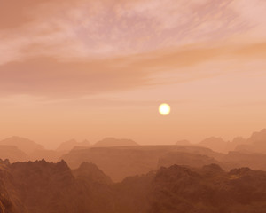Misty sunrise over rough mountain landscape.