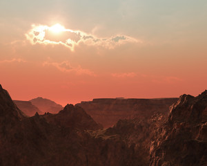 Steep rough mountains at cloudy hazy sunset.