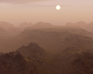 Misty sunrise over rough mountain landscape.