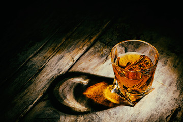 whiskey with ice cubes on wooden background