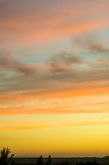 Landscape with dramatic light - beautiful golden sunset with saturated sky and clouds.