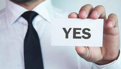Businessman showing business card with Yes text.