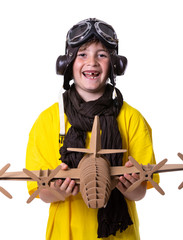 Fototapeta na wymiar Young boy with yellow T-shirt, aviator goggles, plane and world ball smiling