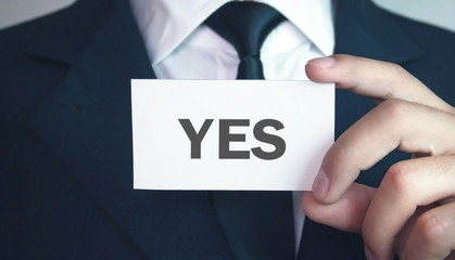 Businessman showing business card with Yes text.