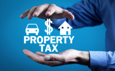 Man holding Property Tax text, with car, dollar, house sign.