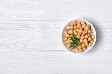 Cooked chickpeas in white bowl with spice of rosemary