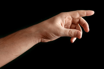 Man's hand touching or pointing to something isolated on black background. Close up. High resolution.