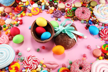 easter candies with jelly and sugar. colorful array of different childs sweets and treats on pink