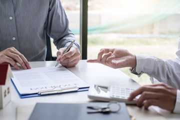 Real estate broker agent presenting and consult to customer to decision making sign insurance form agreement, home model, concerning mortgage loan offer for and house insurance