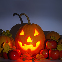 Pumpkin-head, nuts, apples and yellow leaves on a gloomy background. Halloween is a fun holiday.