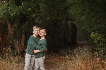 Two brother huging each other outdoor, smiling and laughing