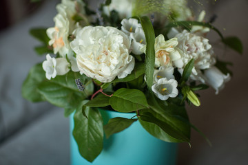 Spring bouquet in a blue box. Peonies, bells, lavender. White flowers for the bride. Soft selective focus