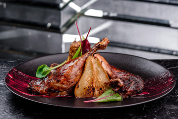 Exclusive restaurant meals. Duck confit with baked pear and cranberry sauce served on snow dark...