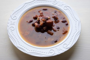 Homemade bean soup , vegetables ,bacon and spices. Detail of bowl of bean soup with large beans