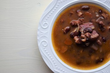 Homemade bean soup , vegetables ,bacon and spices. Detail of bowl of bean soup with large beans