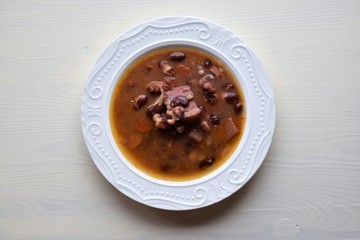 Homemade bean soup , vegetables ,bacon and spices. Detail of bowl of bean soup with large beans