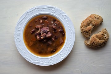 Homemade bean soup , vegetables ,bacon and spices. Detail of bowl of bean soup with large beans
