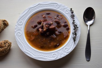 Homemade bean soup , vegetables ,bacon and spices. Detail of bowl of bean soup with large beans