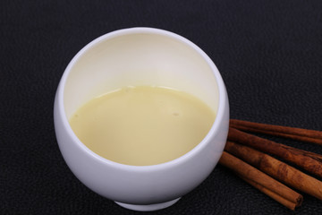 Condenced milk in the bowl with sinnamon and pastry