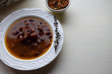 Homemade bean soup , vegetables ,bacon and spices. Detail of bowl of bean soup with large beans
