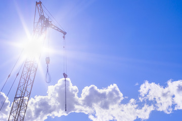 Obraz premium construction crane on a bright Sunny day concept of building and construction of houses