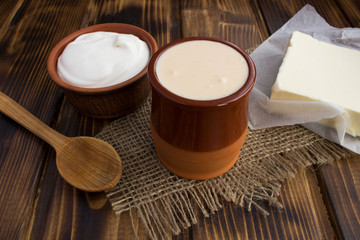 Homemade ryazhenka,sour cream and butter on the rustic  background.Fermented milk products.