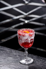 Christmas mulled wine. Red mulled wine in a beautiful faceted glass with cranberries and orange slice. Dark background. close-up. space