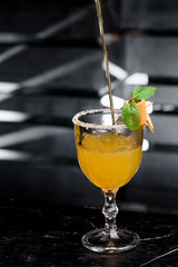 Christmas mulled wine. White citrus mulled wine in a beautiful faceted glass decorated with mint and citrus slice. Dark background. close-up. space