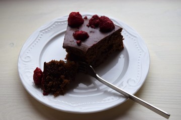 Delicious chocolate pie decorated with raspberries and sweets . Cooked at home.