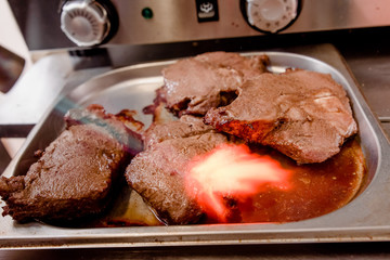 Chef burns raw meat mini blow torch in the kitchen. close up. The process of cooking meat