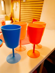 children's colored plastic tableware, blue, pink and orange glasses for party and birthday party.