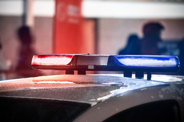 red and blue flashing lights of a police car on a busy square