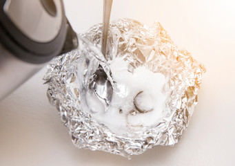 A solution of baking soda(Sodium bicarbonate) and warm water will remove the tarnish from silver when the silver is in contact with a piece of aluminium tin foil. Silver jewellery in baking soda.