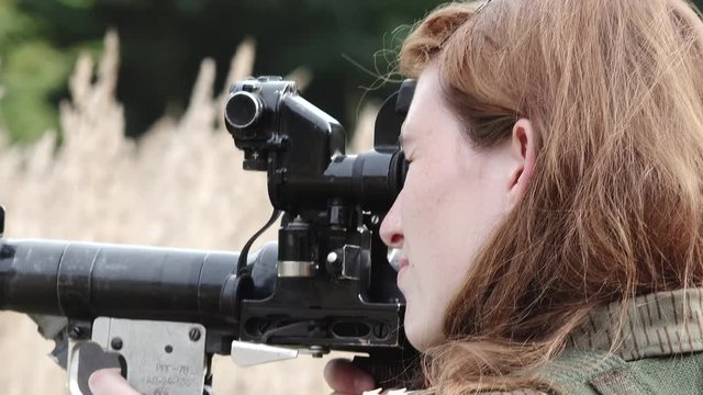 Close female soldier aim with rocket launcher