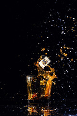 Obraz na płótnie Canvas whiskey with splash on black background