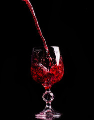 Red wine pouring into wine glass
