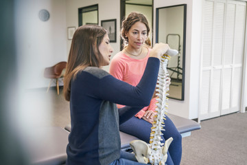 Physiotherapist talking with patient about spine injury