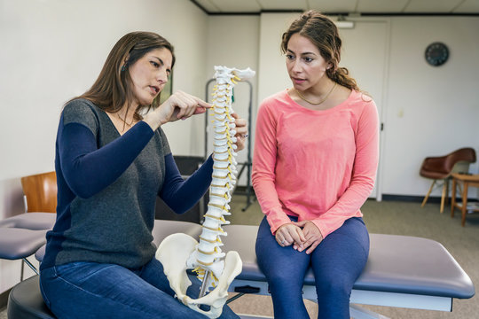 Physiotherapist talking with patient about spine injury