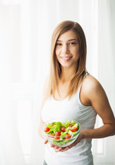 Obraz na płótnie Canvas Diet. Portrait of a happy playful girl eating fresh salad