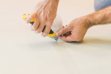 European man working at home - laying polystyrene substrate for laying laminate