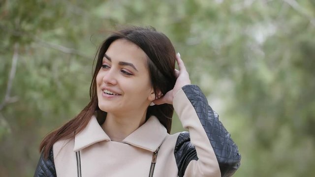 strong wind wawing hair of the beautiful young woman in the park. Nature background